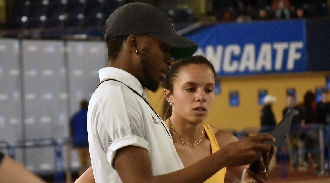 Coach Ernest reviewing video with an athlete at an NCAA meet